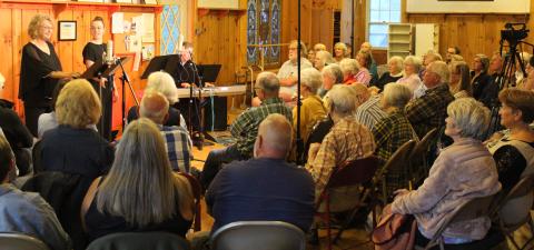 The crowd in Lake Clear listens to Margaret Chalker and Mekayla Fountaine